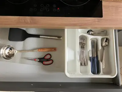 a drawer in a cabinet filled with utensils at FAIROME Apartment Albricci in Rome