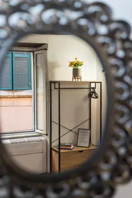 a mirror with a plant on a table with a window at SorinaHome Campo de Fiori Loft in Rome
