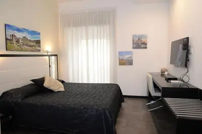 a bedroom with a bed and a desk with a computer at Capital Suite in Rome
