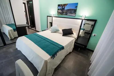 a bedroom with a bed with a green and white blanket at Capital Suite in Rome