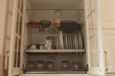 a cupboard filled with dishes and other kitchen items at Green House in San Lorenzo Termini in Rome