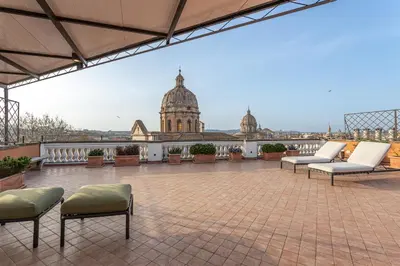a patio with benches and tables on a building at Arenula16 - Attico con terrazza panoramica in Rome