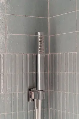 a shower head in a tiled bathroom at Zoe Vatican rooms in Rome
