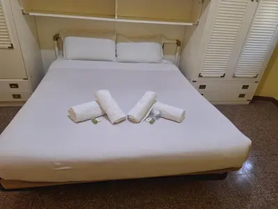 a bed with two rolled towels on it at Kotel lorenzo il magnifico in Rome