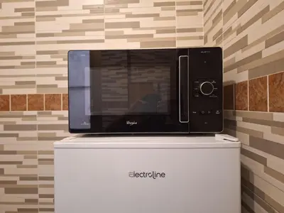 a microwave sitting on top of a refrigerator at Kotel lorenzo il magnifico in Rome