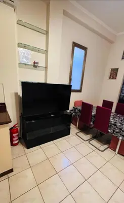 a living room with a flat screen tv and red chairs at Kotel lorenzo il magnifico in Rome