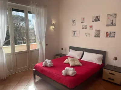 a bedroom with a red bed with two towels on it at Appartamento Monteverde in Rome