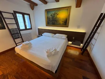 a bedroom with a bed with white sheets at Domus Colosseum, detached house just few steps from the Colosseum in Rome