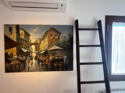 two pictures on a white wall with a ladder at Domus Colosseum, detached house just few steps from the Colosseum in Rome