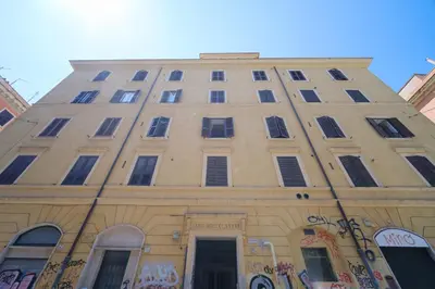 a tall building with windows and graffiti on it at St Lawrence by BuddyRent in Rome