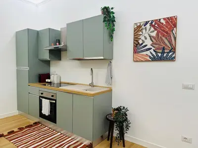 a kitchen with green cabinets and a sink at Friendly Apartment San Saba in Rome