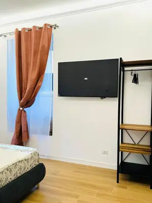 a bedroom with a flat screen tv on a wall at Friendly Apartment San Saba in Rome