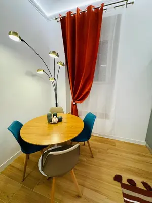 a table and chairs in a room with a red curtain at Friendly Apartment San Saba in Rome
