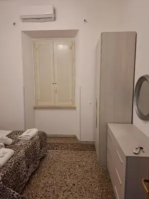a room with a bed and a dresser and a refrigerator at APARTAMENTo FANTI22 in Rome