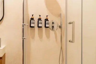 a shower with four bottles on a wall at Cunabu Morosini in Rome