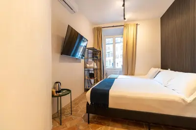 a hotel room with a bed and a flat screen tv at Cunabu Morosini in Rome