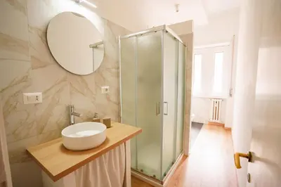 a white bedroom with two beds and a window at Simi Roma - Carpegna in Rome