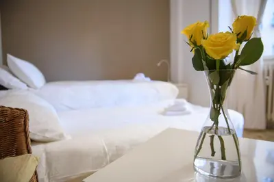 a vase filled with yellow roses sitting on a table at Cesare a Trastevere in Rome