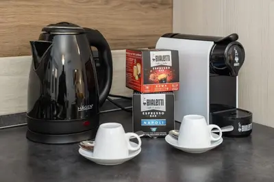 a coffee pot and two cups on a counter at La Dimora del Gianicolo in Rome