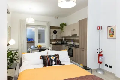 a bedroom with a large bed and a kitchen at La Dimora del Gianicolo in Rome