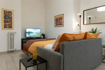 a bedroom with a bed and a couch and a television at La Dimora del Gianicolo in Rome