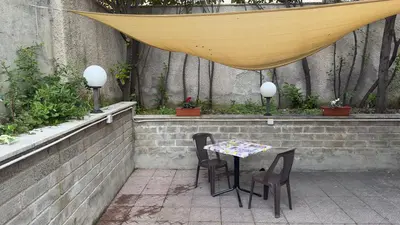 a table and chairs in a patio with a canopy at La Casetta tiny house in Rome in Rome