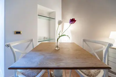 a vase with a flower sitting on a wooden table at Beautiful in Rome