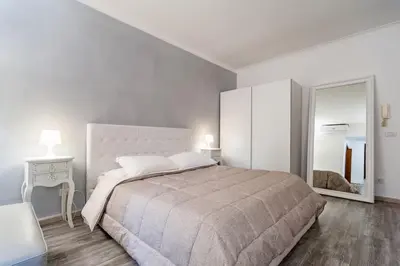 a white bedroom with a large bed and a mirror at Awesome in Rome