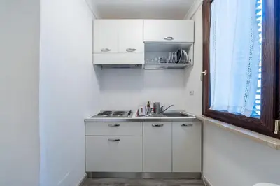 a white kitchen with a sink and a window at Awesome in Rome