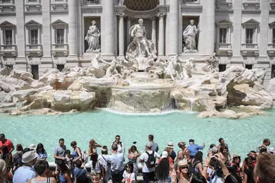 a crowd of people standing around a fountain in front of a building at Awesome in Rome