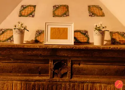 a framed picture on top of a fireplace with flowers at Gorgeous House Trastevere in Rome