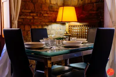 a dining room table with chairs and a lamp at Gorgeous House Trastevere in Rome