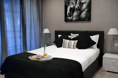 a bedroom with a black and white bed with a tray on it at Gregori Guest House in Rome