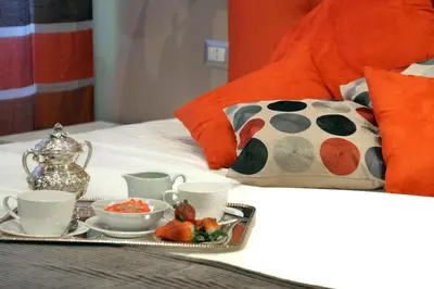a tray of food on a bed with tea and strawberries at Gregori Guest House in Rome