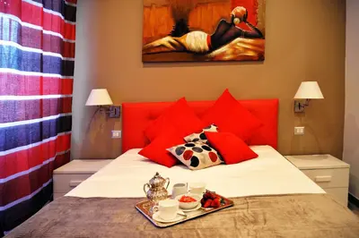 a bed with red pillows and a tray of food on it at Gregori Guest House in Rome