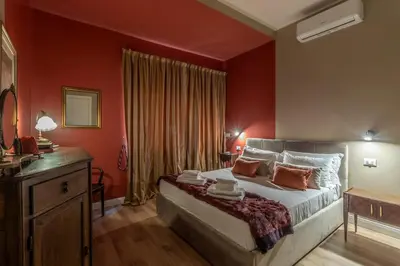a bedroom with a large bed with red walls at OldStation in Rome