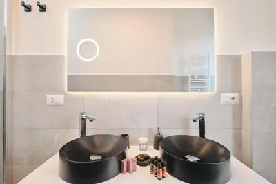 a bathroom with two black sinks on a counter at Colosseo-San Giovanni, New Apartment Wi-Fi & A-C in Rome