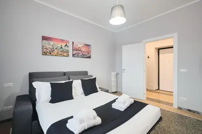 a bedroom with a large bed with white sheets at Colosseo-San Giovanni, New Apartment Wi-Fi & A-C in Rome