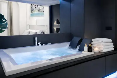 a bathroom with a blue tub with a mirror at LUX- Spanish Steps 60A Exclusive Suite Apartment in Rome