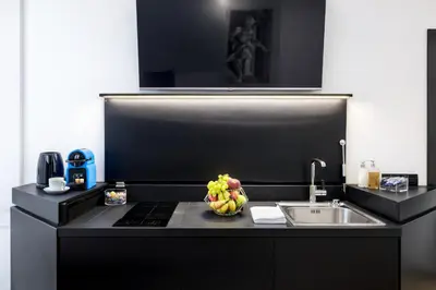a kitchen with a sink and a bowl of fruit on a counter at LUX- Spanish Steps 60A Exclusive Suite Apartment in Rome