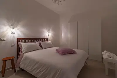 a bedroom with a white bed with a pink pillow on it at Joy Home in Rome