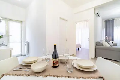 a dining room table with white plates and wine bottles at Joy Home in Rome