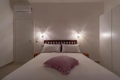 a large white bed with a purple pillow on it at Joy Home in Rome