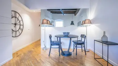 a dining room with a table and chairs and a clock at Delightful apartment-Rome Center in Rome