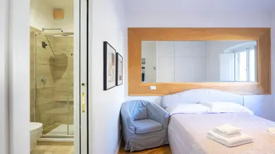a bedroom with a bed and a chair and a shower at Delightful apartment-Rome Center in Rome