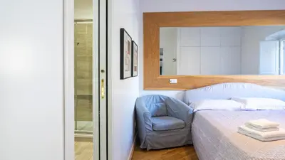 a bedroom with a bed and a chair and a mirror at Delightful apartment-Rome Center in Rome