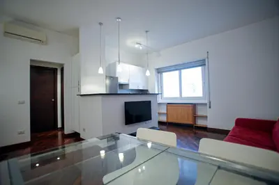 a living room with a glass table and a red couch at Ponte Milvio Cozy 1BR Apartment in Rome