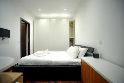 a bedroom with a bed with white sheets and pillows at Ponte Milvio Cozy 1BR Apartment in Rome