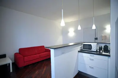 a kitchen with a red couch and a microwave at Ponte Milvio Cozy 1BR Apartment in Rome