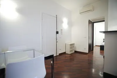 a white room with a glass table and white chairs at Ponte Milvio Cozy 1BR Apartment in Rome